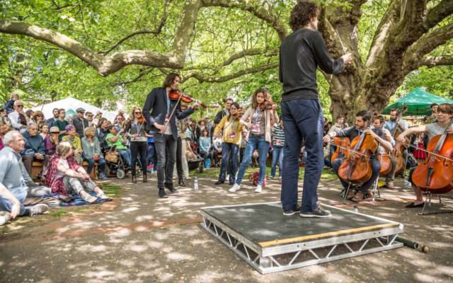 Photo from NNF16 show Beethoven Safari, members of Aurora Orchestra perform outside in Chapelfield Gardens on a sunny day.