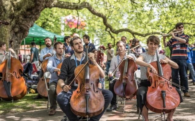 Photo from NNF16 show Beethoven Safari, members of Aurora Orchestra perform outside in Chapelfield Gardens on a sunny day.