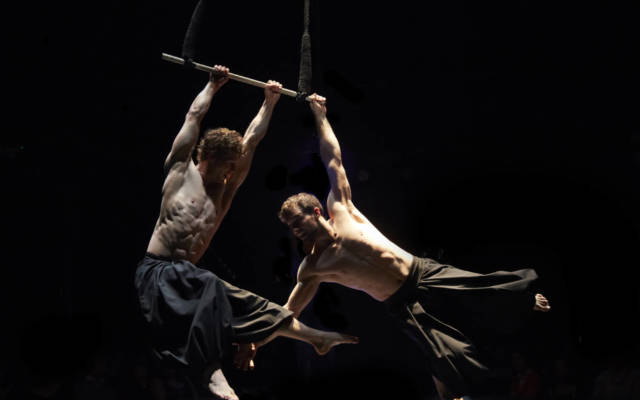 Photo from NNF15 show What Will Have Been, two men hang from a trapeze.