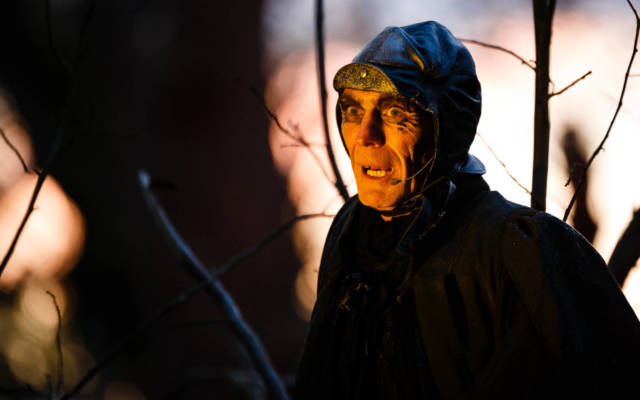 Photo from NNF15 show Wolf's Child, a man wearing a black cloak and hat looks intensely at the left hand side of the frame.