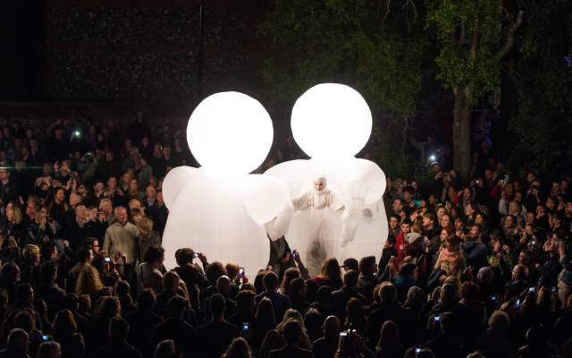 Photo from NNF13 show The Kindness of Strangers, two huge white, inflatable figures stand facing each other, surrounded by a big crowd.