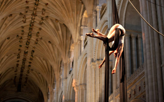Photo from NNF12 show How Like An Angel, a woman hangs from two pieces of silk in Norwich Cathedral.