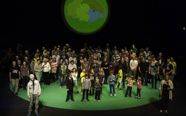 Photo from NNF12 show 100% Norfolk, 100 people stand on a large stage.