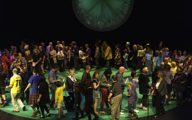 Photo from NNF12 show 100% Norfolk, a group of 100 people on stage, walking around in a big circle.