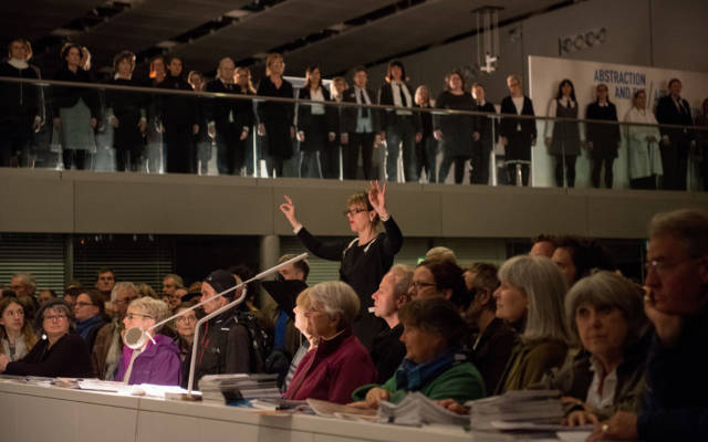 Image taken in the Sainsbury Centre for Visual Arts, The Voice Project Choir stand on the mezzanine and the crowd watch from below.