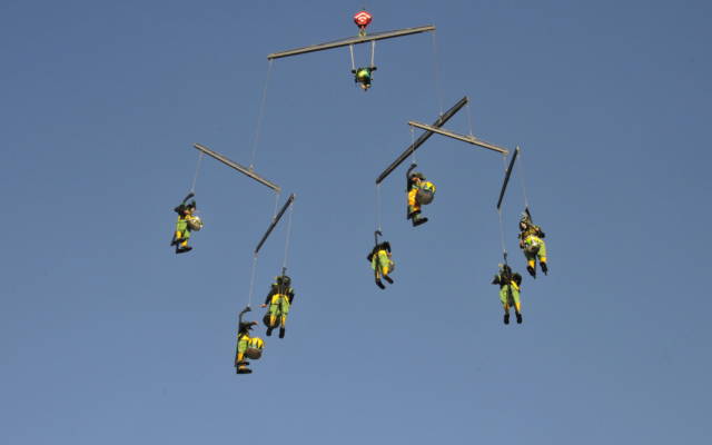 Drummers suspended by crane forming a mobile