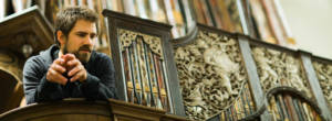 Kit Downes in front of church organ.