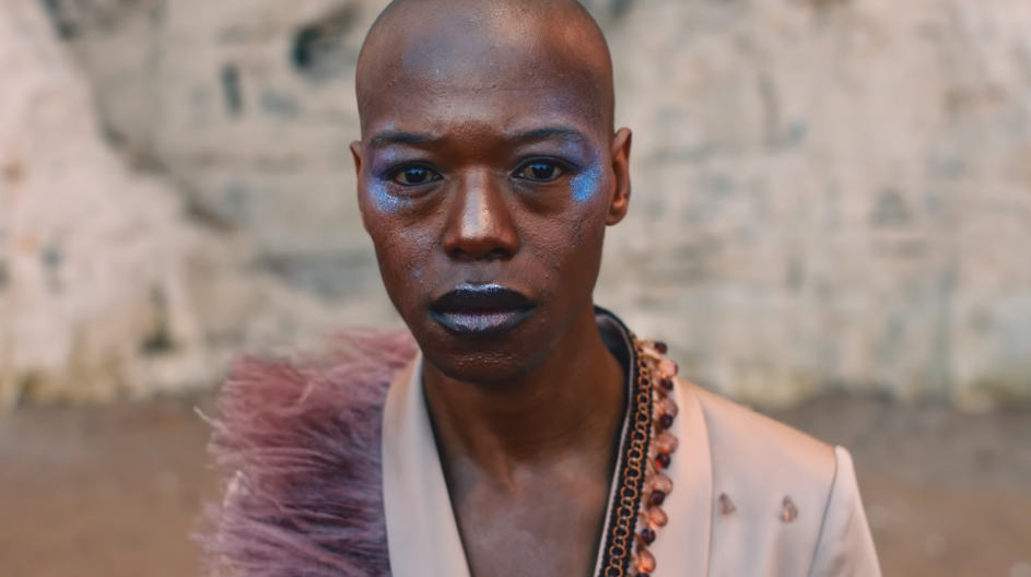 Photo: Nakhane looking into the camera wearing dark blue lipstick, and blue eyeshadow.