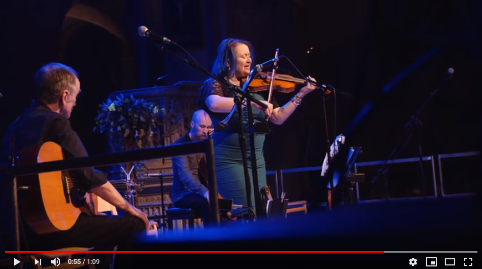 Video still: a woman on stage with a violin.